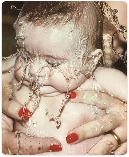 Foto de um bebe sendo batizado